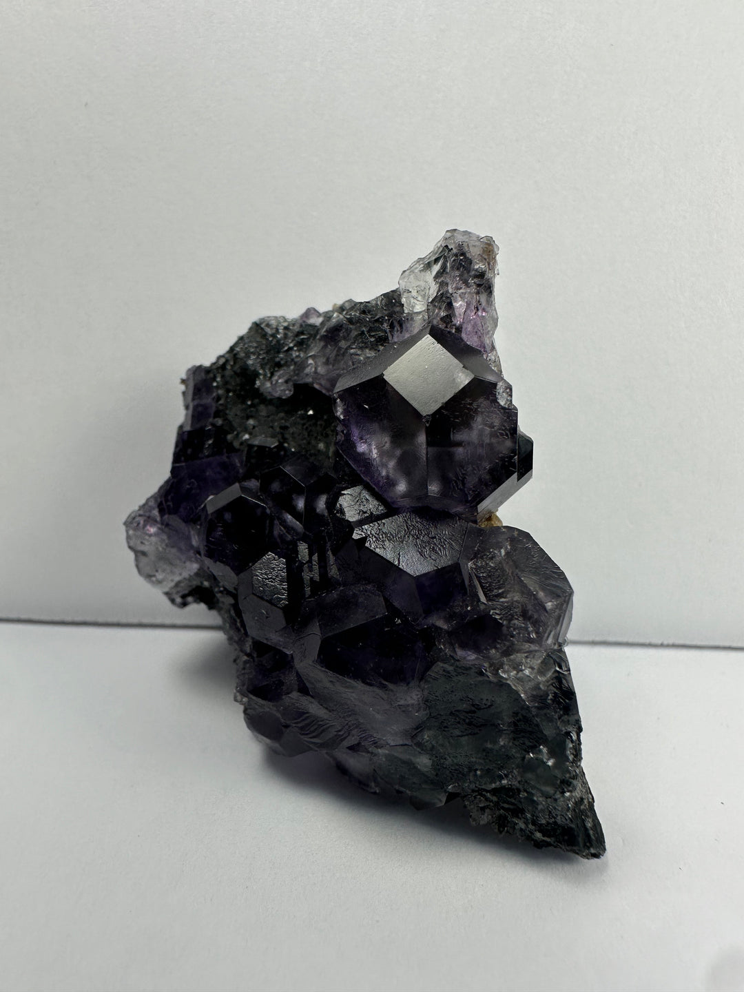 Purple fluorite crystals on dark matrix base, angled close view