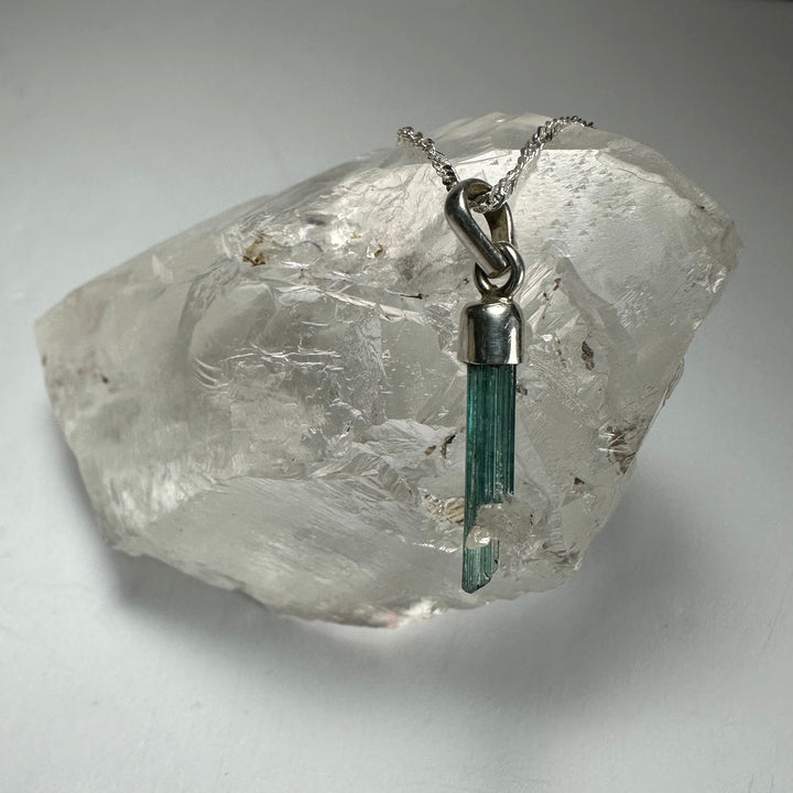 Green tourmaline pencil pendant with silver-toned chain and loop bail