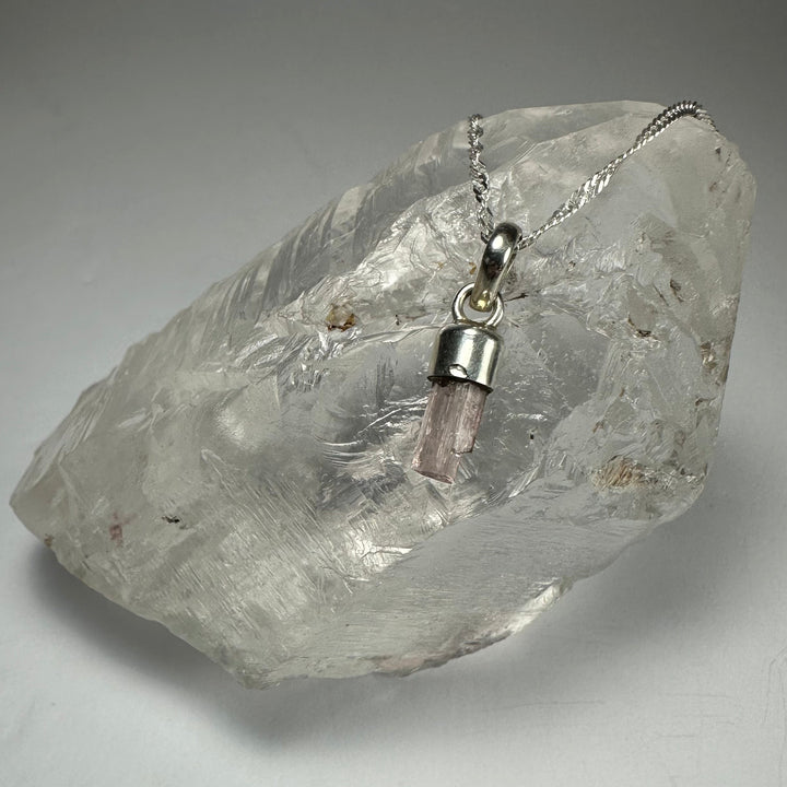 Pink tourmaline pencil pendant with silver-toned chain and loop bail