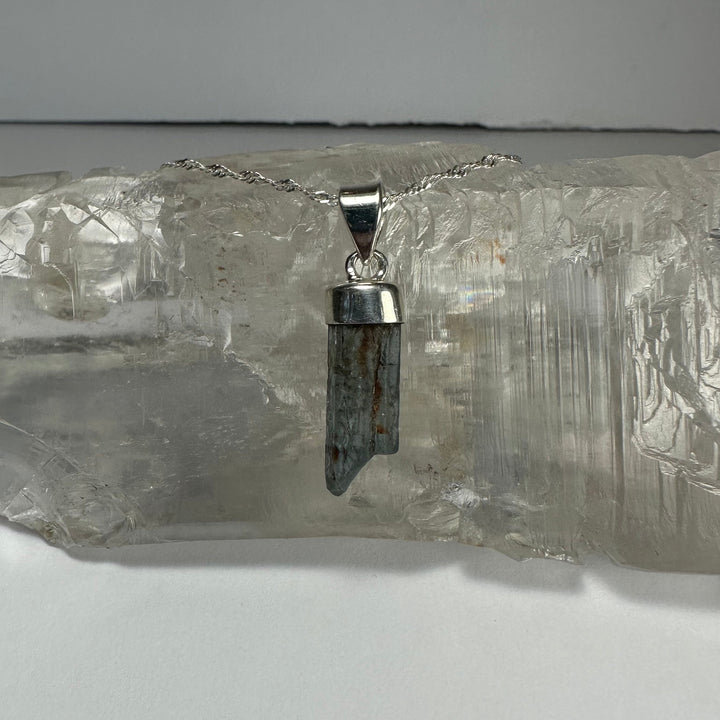 Aquamarine beryl pendant with faceted dark blue stone and silver-tone bail