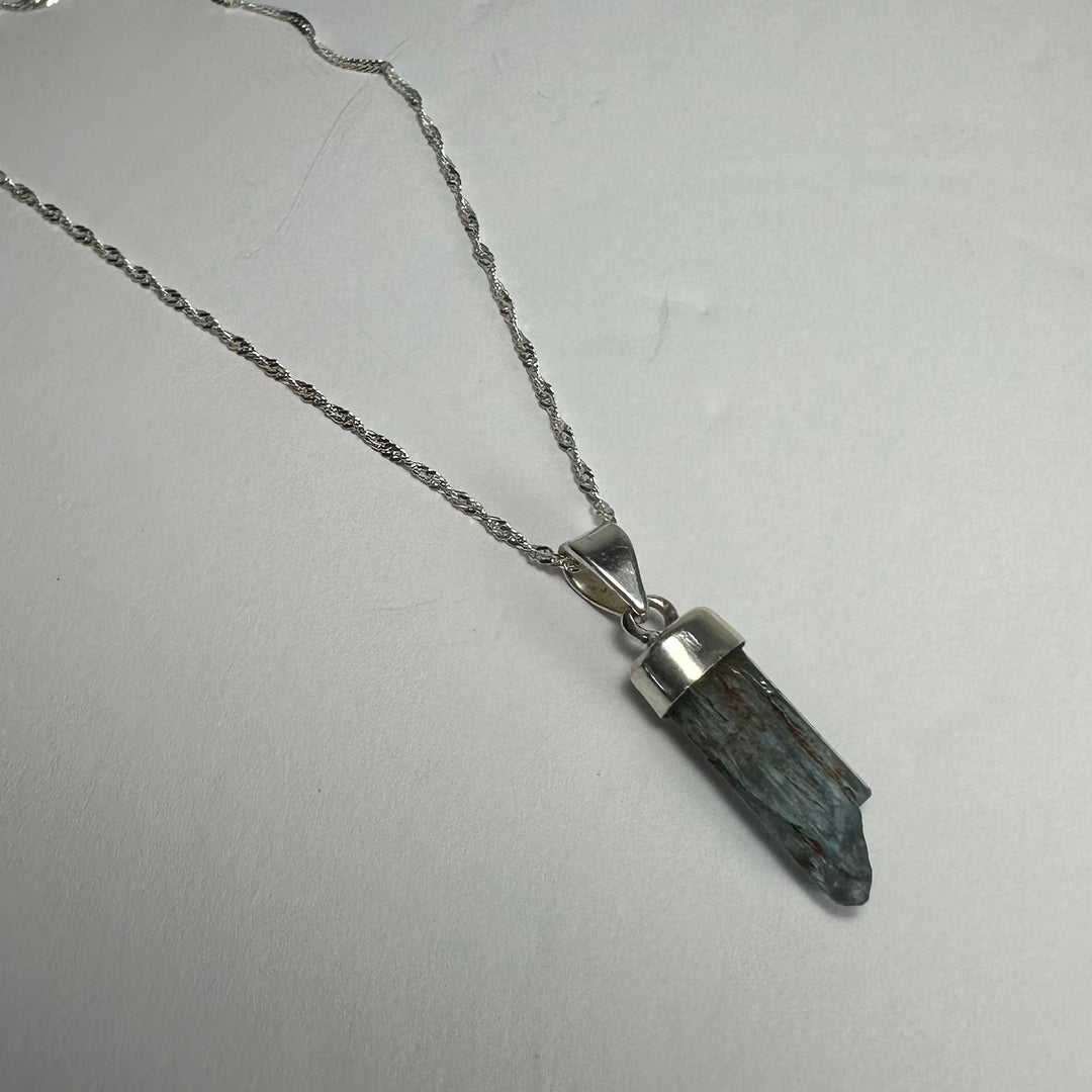Aquamarine beryl pendant with faceted deep blue stone on silver-tone chain