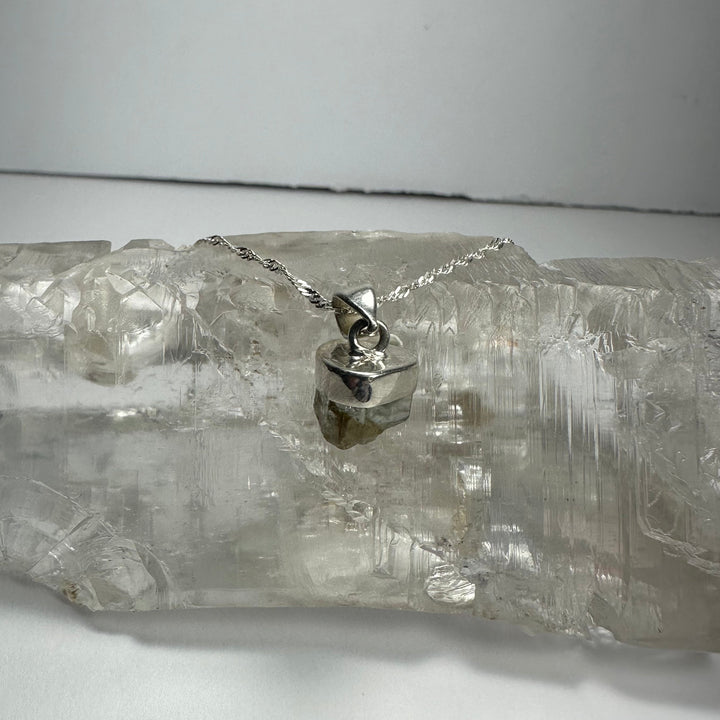 Aquamarine beryl pendant with faceted dark stone and silver-tone bail on chain