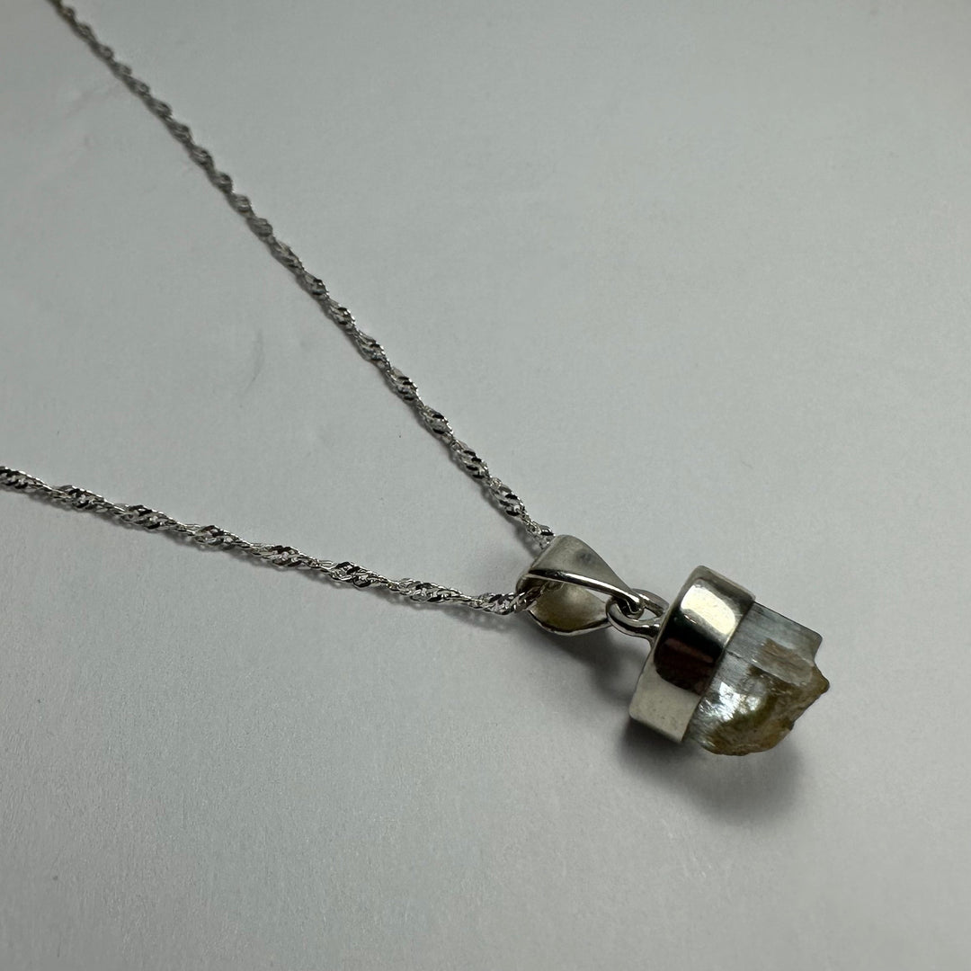 Aquamarine beryl pendant with pale greenish stone on silver-tone chain