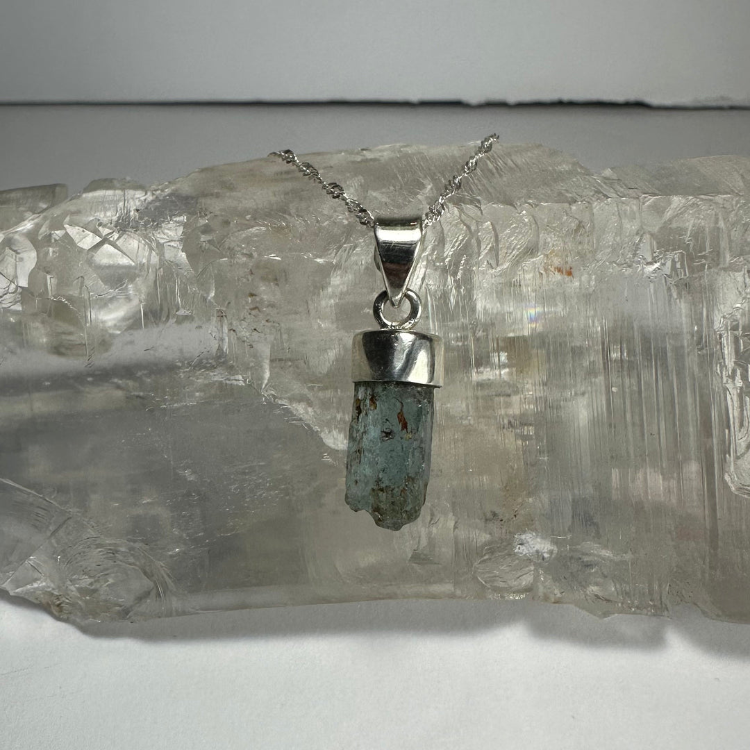 Aquamarine beryl pendant with faceted blue-green stone on silver-tone chain