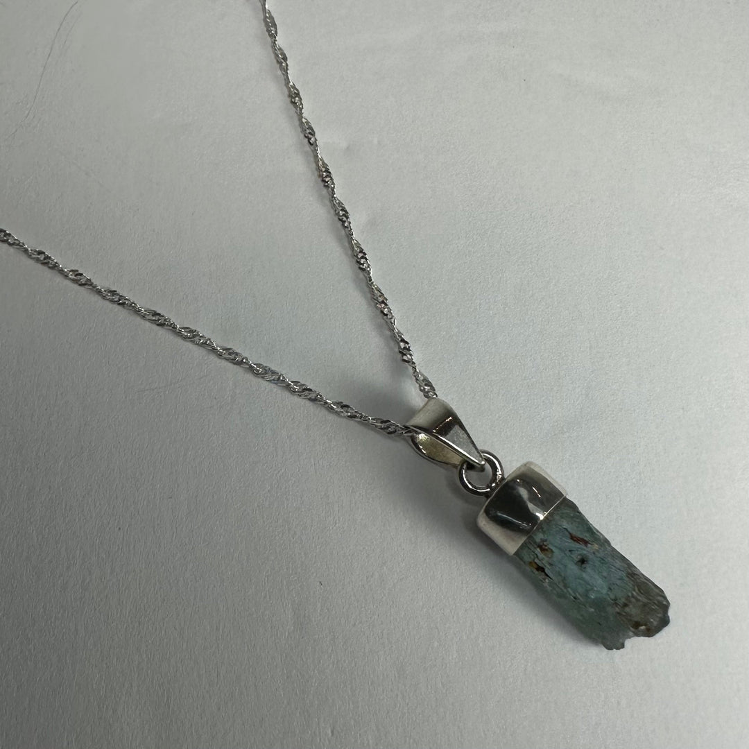 Aquamarine beryl pendant with faceted dark blue stone and silver-tone bail