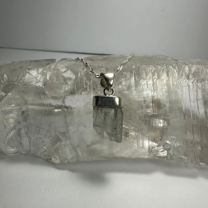 Aquamarine beryl pendant with faceted light gray-green stone and silver-tone bail