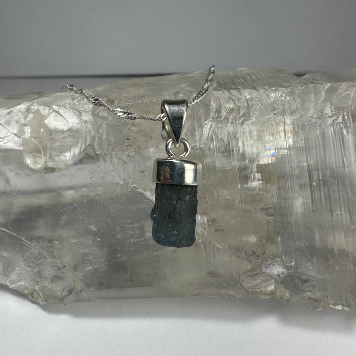 Aquamarine beryl pendant with faceted dark blue stone in square silver setting