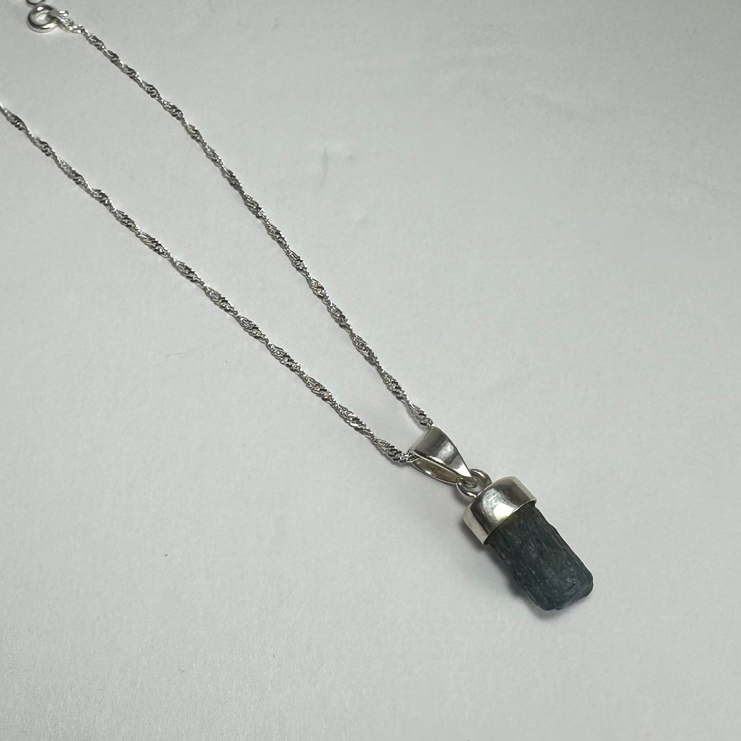 Aquamarine beryl pendant with pointed dark blue stone on silver-tone chain