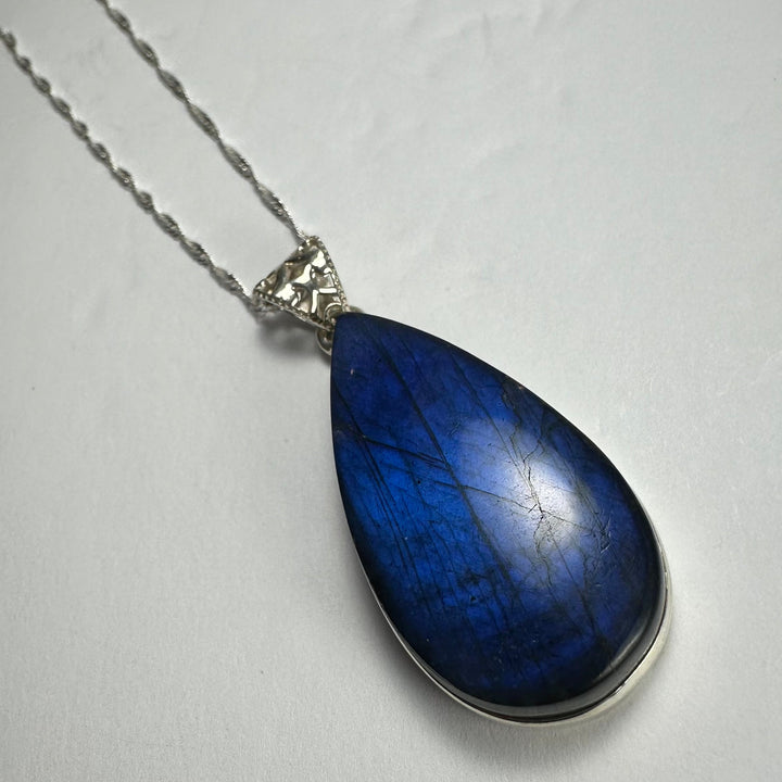 Blue labradorite teardrop pendant with silver-tone chain and decorative bail