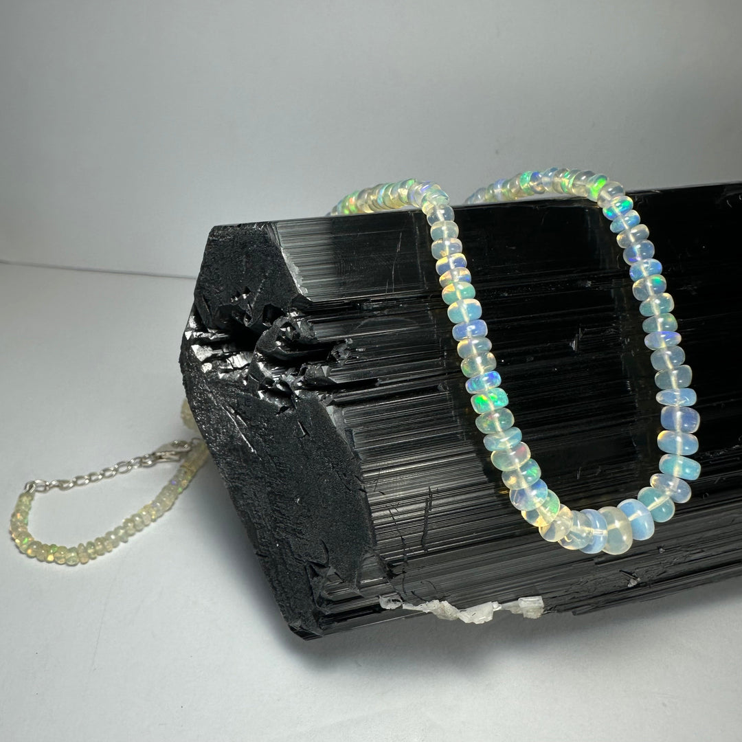 Graduated opal-like bead necklace with round iridescent beads and chain extension