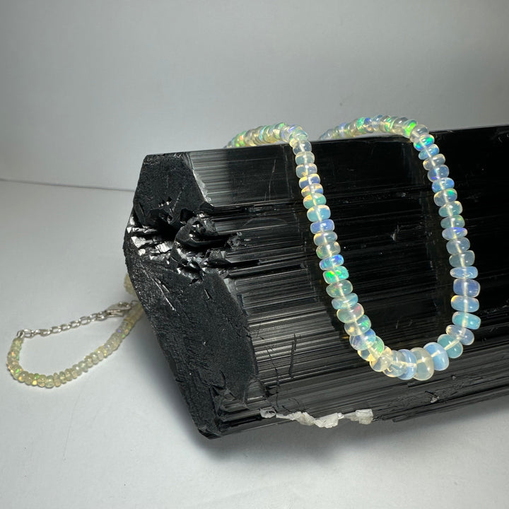 Graduated opal-like bead necklace with round iridescent beads and chain extension