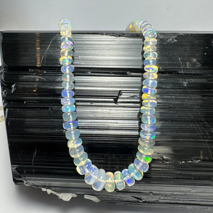 Graduated opal-like bead necklace with round iridescent beads in an oval loop