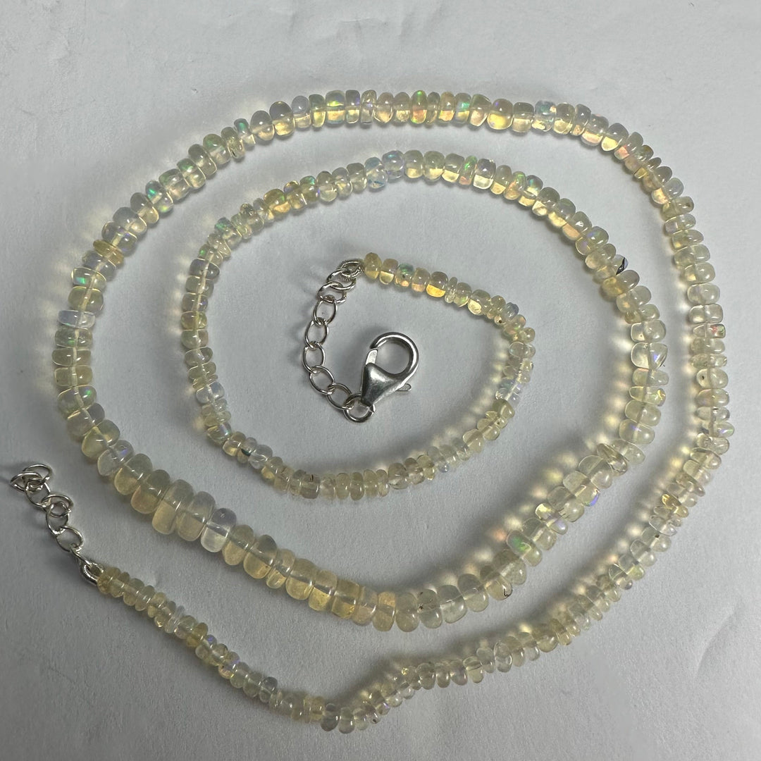 Opal-like bead necklace with silver clasp and three loops of iridescent beads