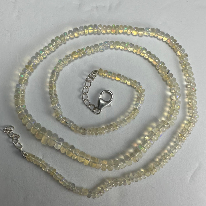 Opal-like bead necklace with silver clasp and three loops of iridescent beads