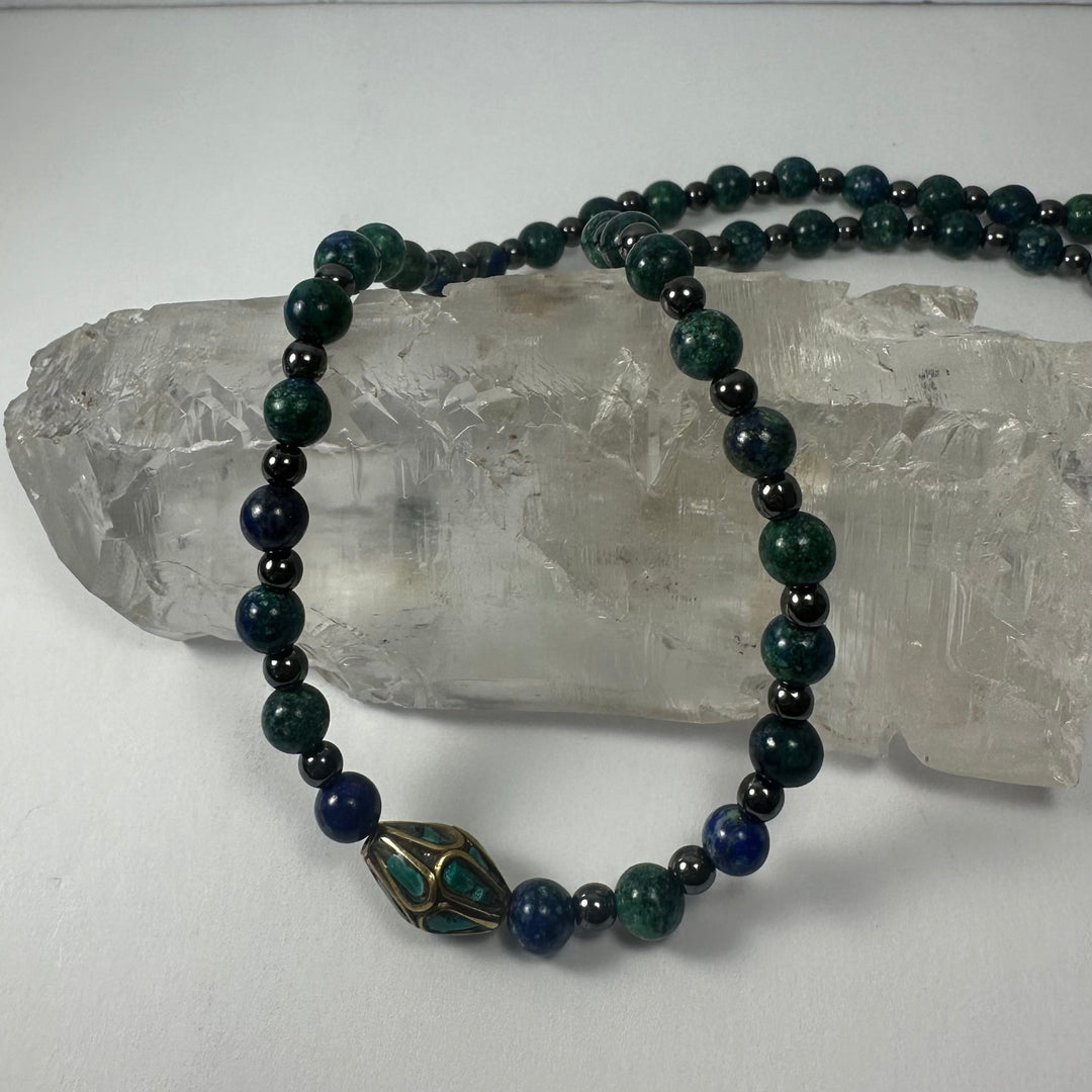 Beaded necklace with dark green and navy beads and brass-and-turquoise drop pendant