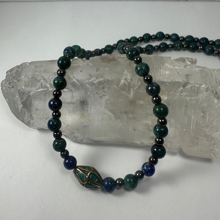 Beaded necklace with dark green and navy beads and brass-and-turquoise drop pendant