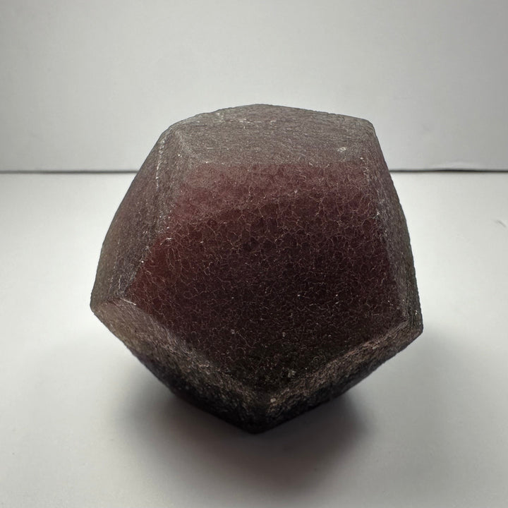 Fluorite dodecahedron, dark burgundy faceted crystal with matte rough texture