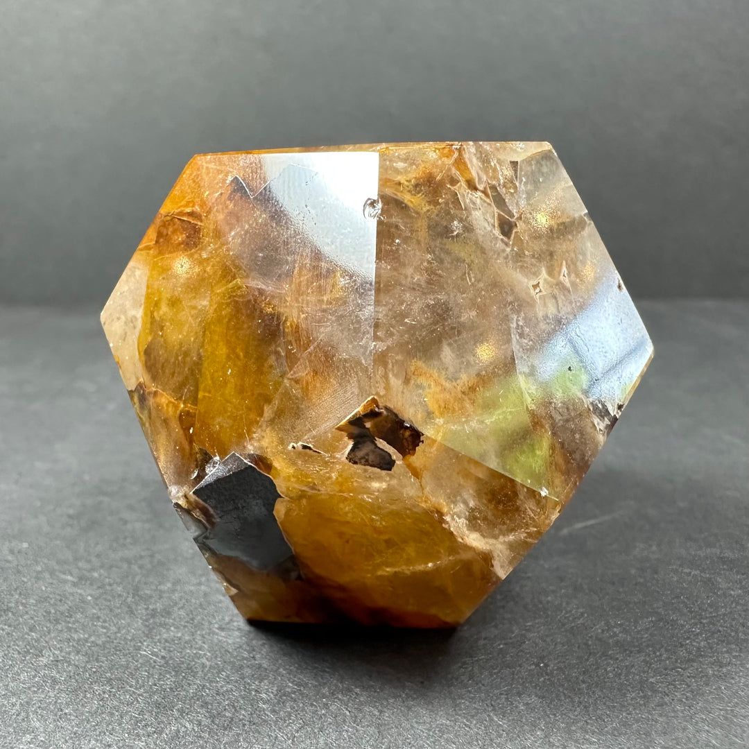 Yellow hematoid quartz dodecahedron with polished facets and small dark inclusions