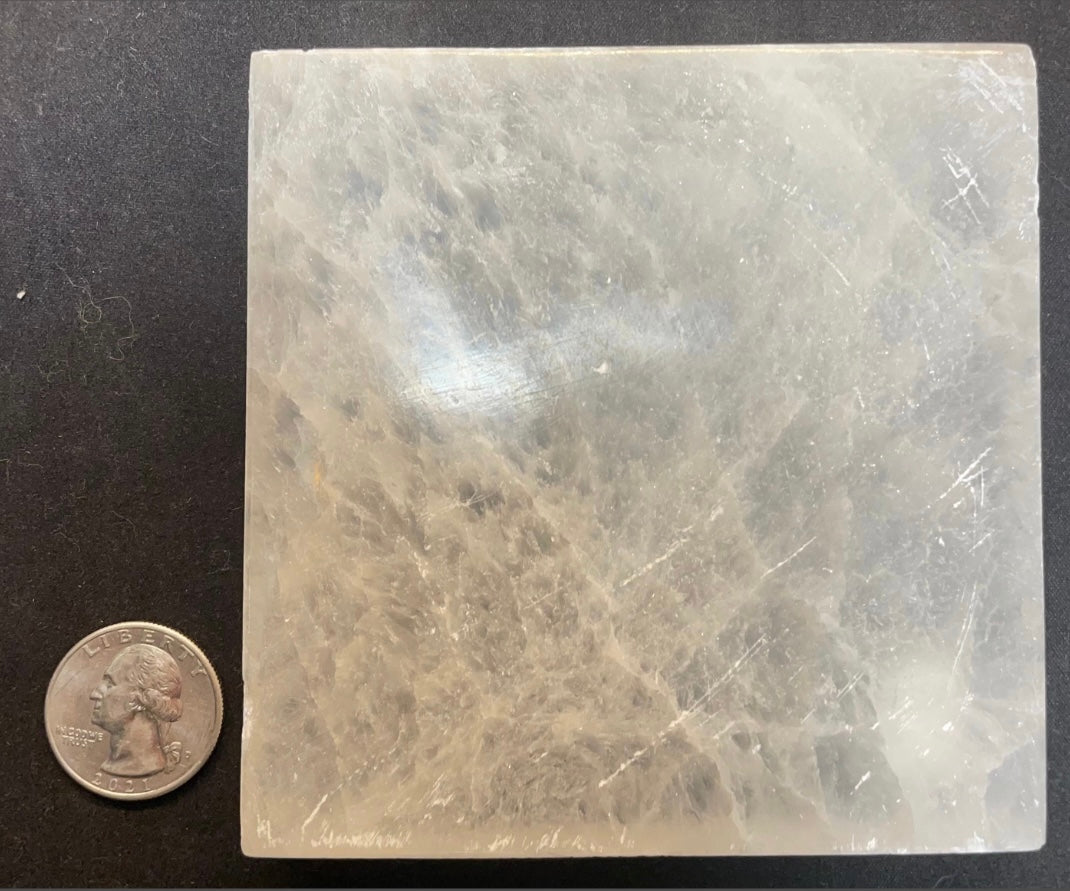 Square selenite crystal charging plate with translucent pale white glow and striations