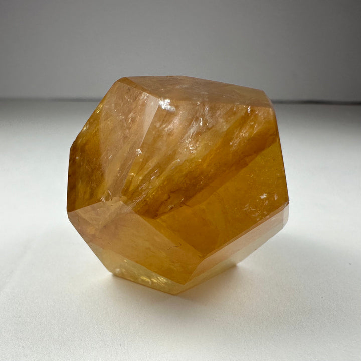 Yellow faceted dodecahedron quartz carving, translucent gold tone