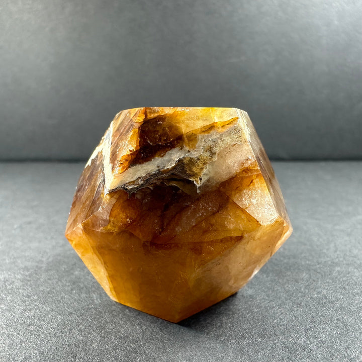 Yellow hematoid quartz dodecahedron with rough top area and clear golden facets