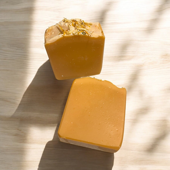 Handmade bar soap, golden amber color; top bar with embedded bits, plus cut bar