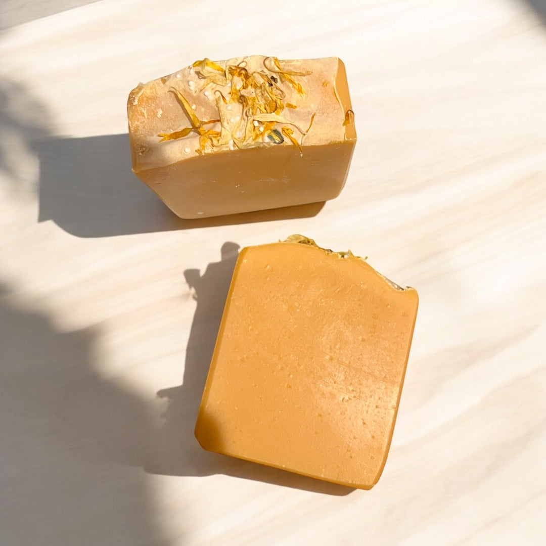 Handmade bar soap, golden amber bars; embedded specks on one bar and smooth cut face