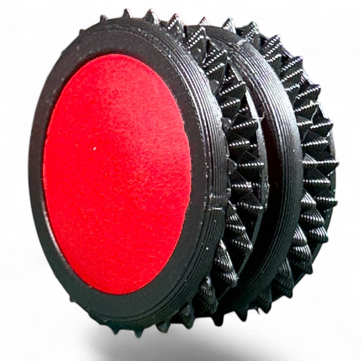 Black fidget moon toy with red oval center and spiky ridged ring layers
