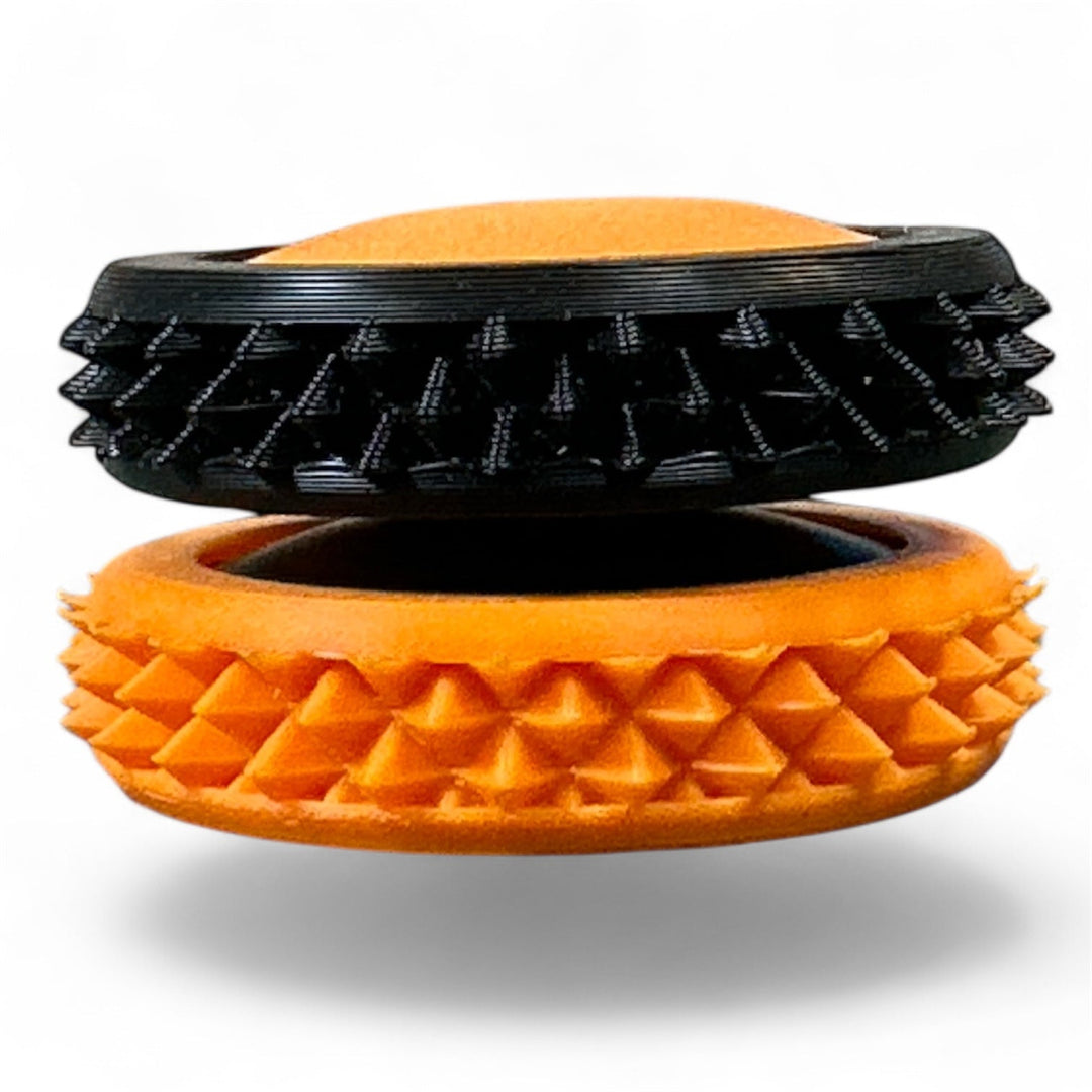 Black and orange spiky fidget gear discs stacked, oval openings visible