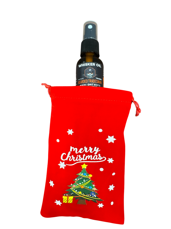Red drawstring Christmas gift bag holding a Whisker Oil bottle