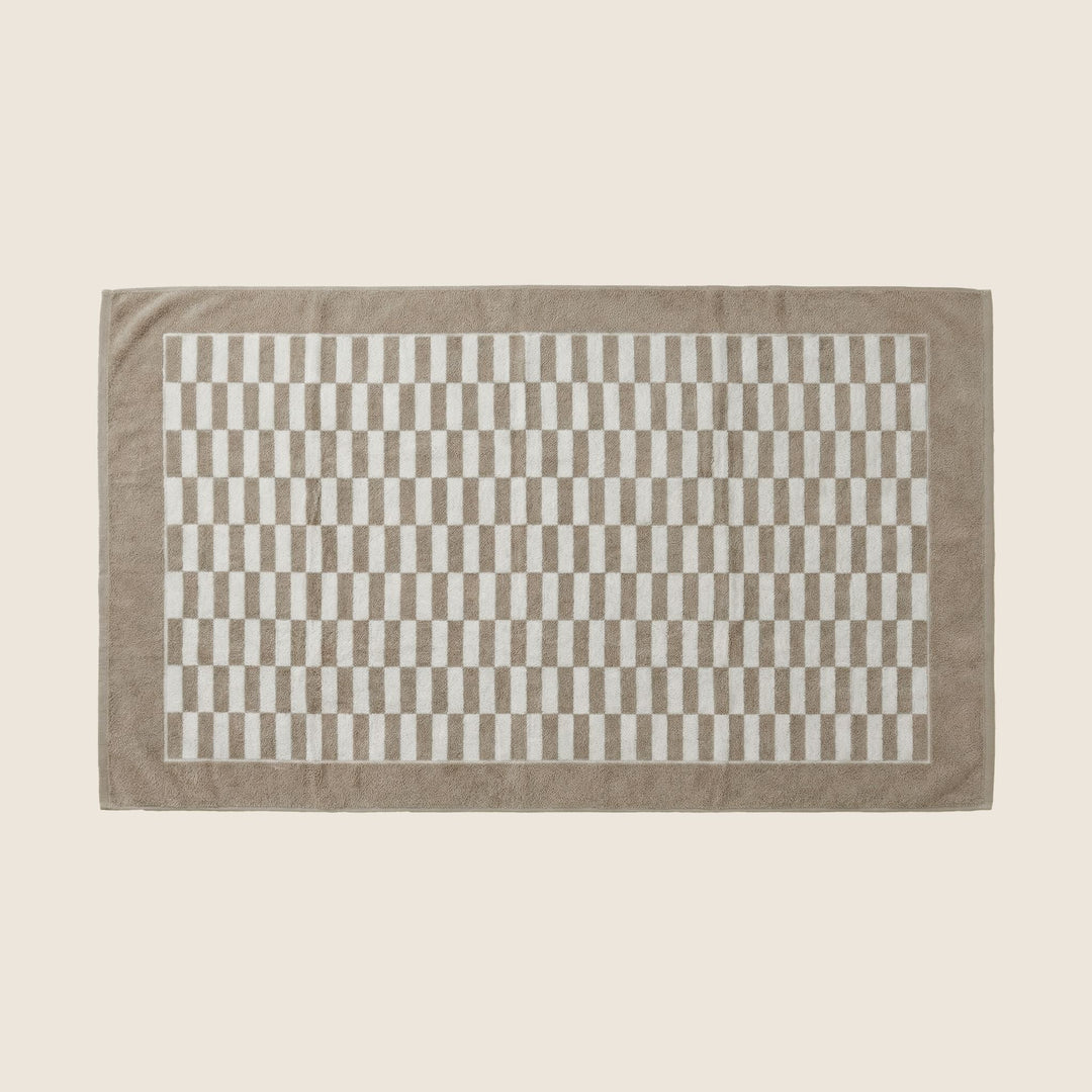 Single beige and white checkered bath towel with gray border, laid flat