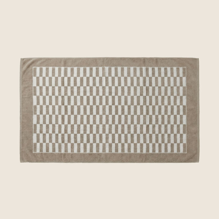 Single beige and white checkered bath towel with gray border, laid flat