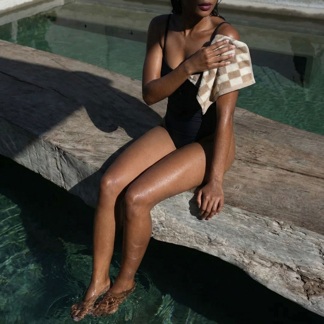 Person holding a tan and ecru checkered cotton towel for drying