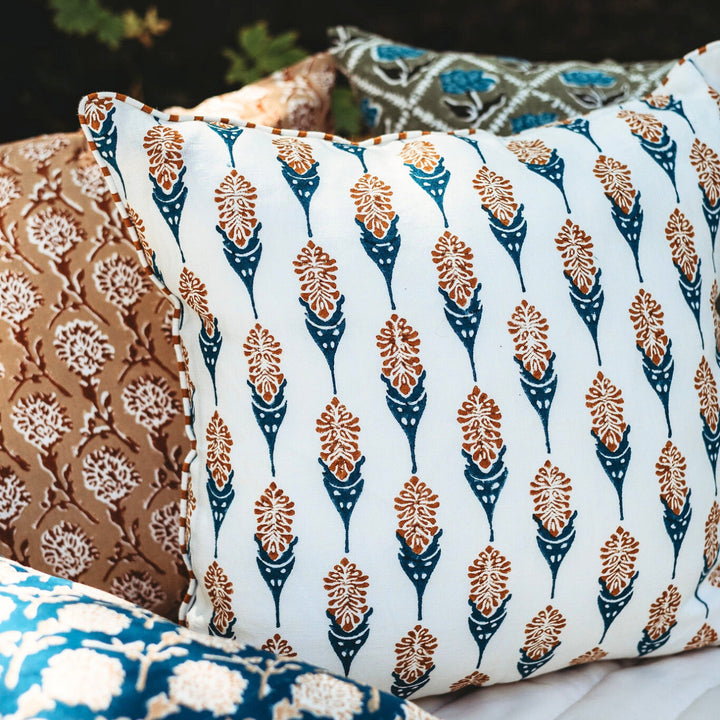 Throw pillow cover with white base and navy teardrop motifs in orange floral print