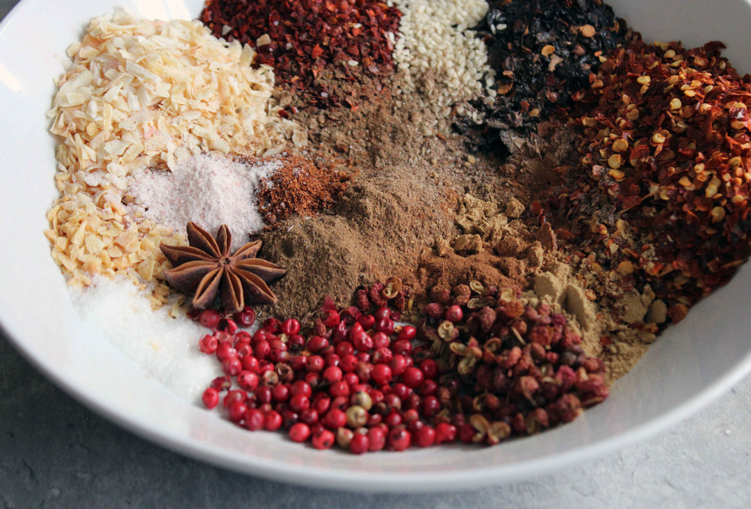 Spiced chili crisp mixture in a bowl with peppercorns and star anise
