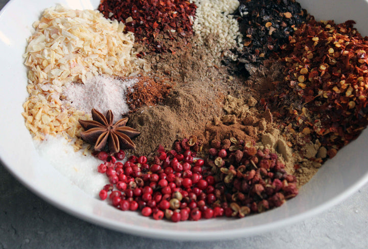Spiced chili crisp mixture in a bowl with peppercorns and star anise