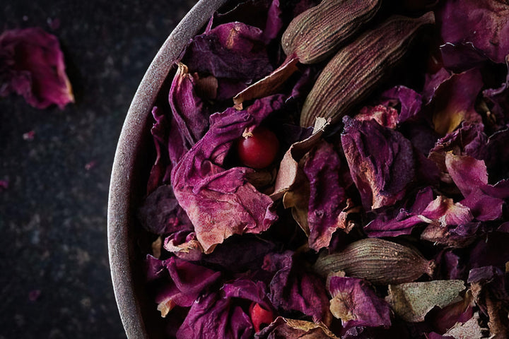 Bowl of dried purple rose petals and spice pieces