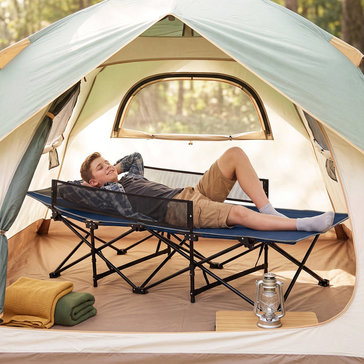 Blue folding camping cot with guardrail, mesh side panels, set up inside a tent