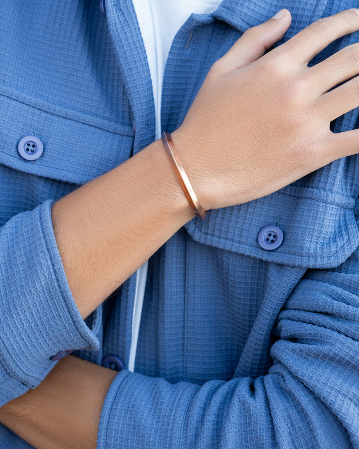 Copper cuff bracelet on wrist, slim polished band