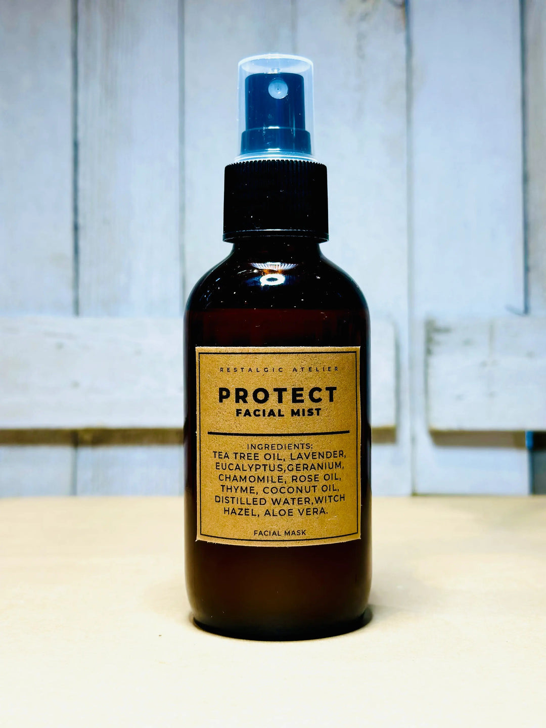 Protect facial mist bottle with blue spray, amber liquid and ingredient label