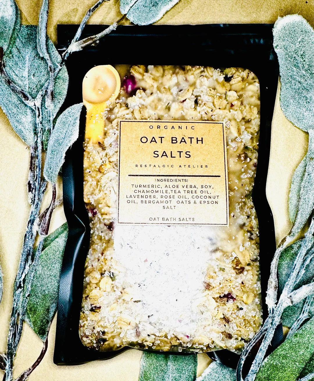 Organic oat bath salts box in black tray with herbs and bath salts