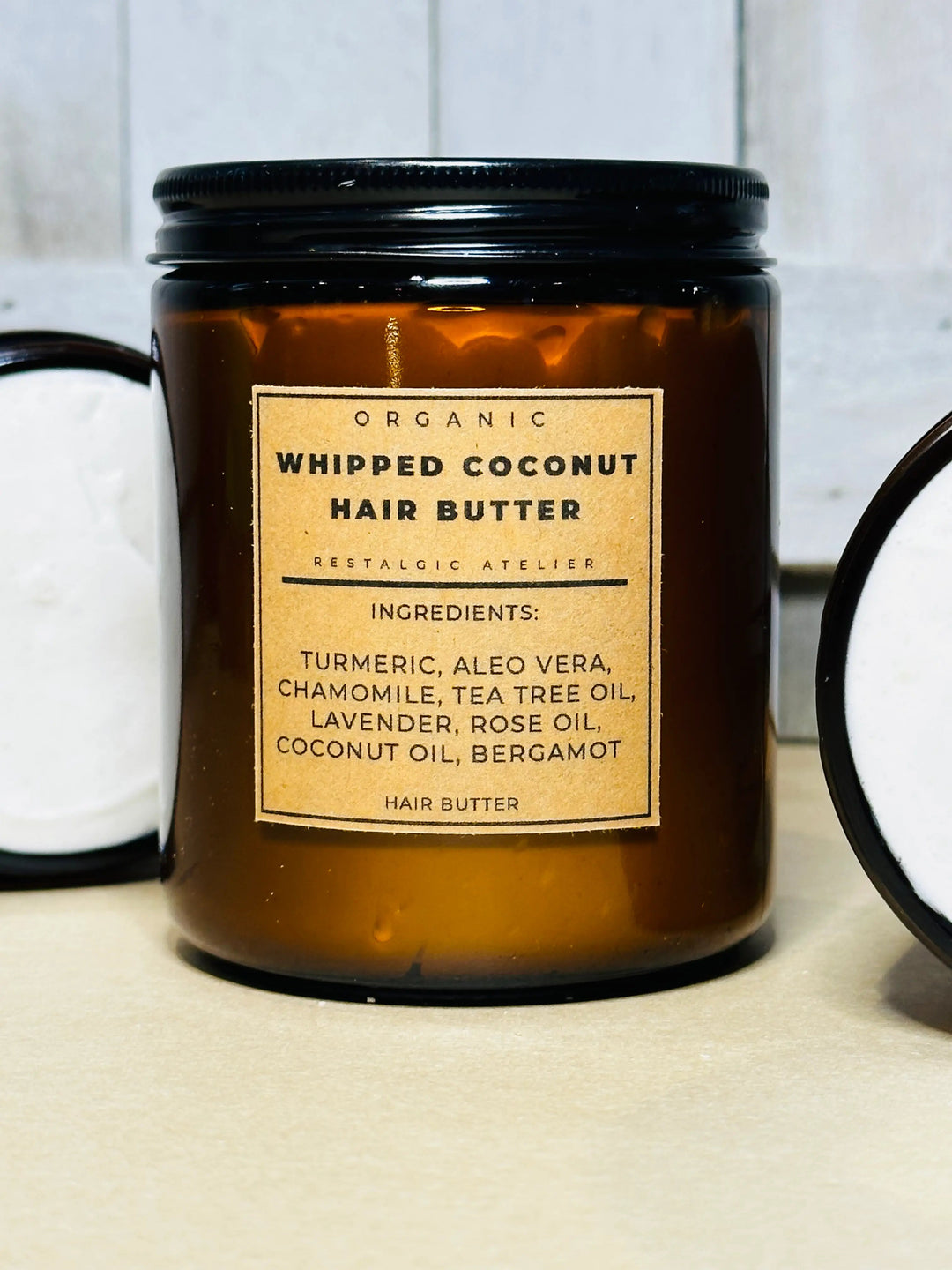 Organic whipped coconut hair butter jar with black lid, labeled ingredients