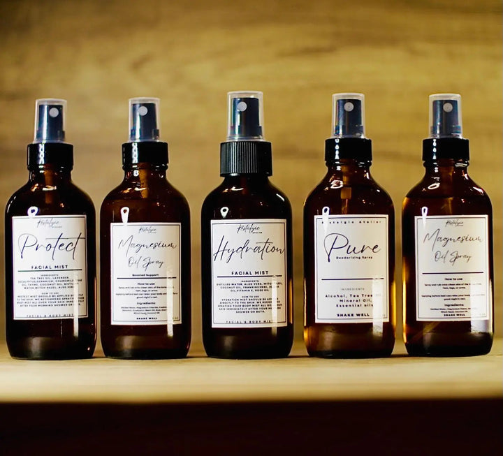 Set of facial mist spray bottles with silver pumps and dark amber liquid