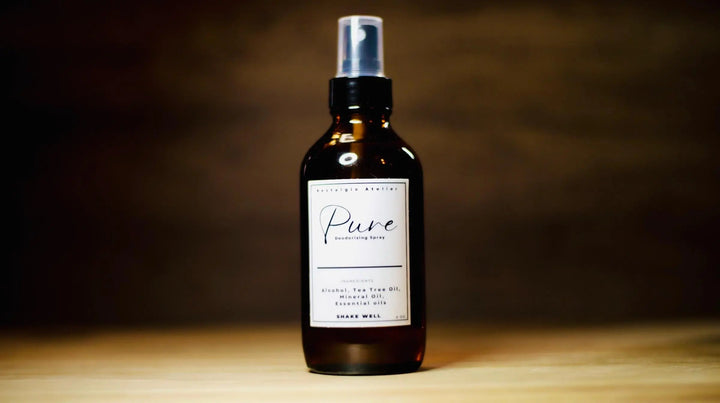 Facial mist spray bottle with silver pump, dark amber liquid, "Pure" label
