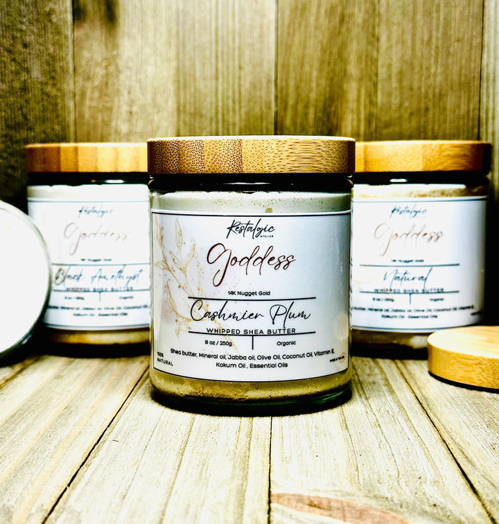 Shimmer body butter jar with gold cap, centered on tabletop with two other jars behind