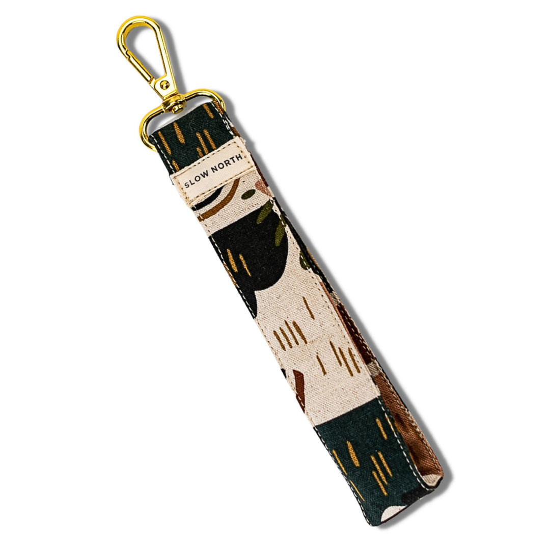 Fabric wristlet keychain with gold clip and black tan abstract print, text &