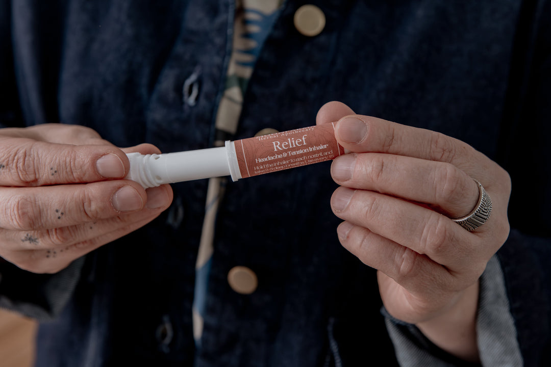 Aromatherapy inhaler tube with Relief label, held in hands.