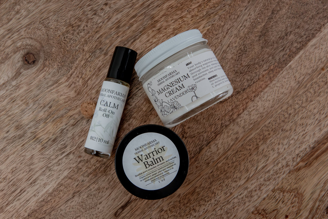 Skincare recovery set laid out: balm tin, roll-on oil bottle, and cream jar.