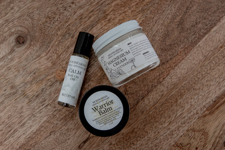Skincare recovery set laid out: balm tin, roll-on oil bottle, and cream jar.