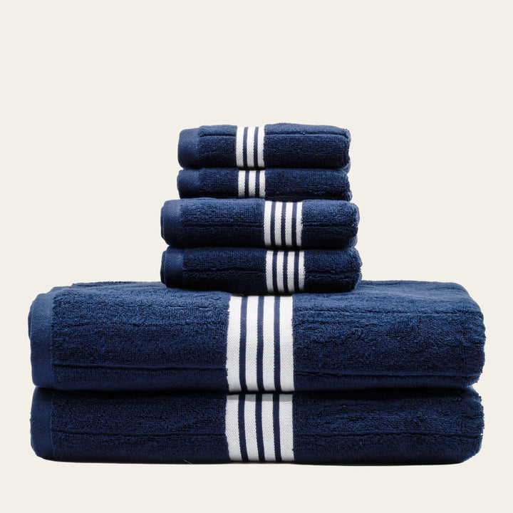 Navy cotton towels with white striped bands, folded stack of 3 towels